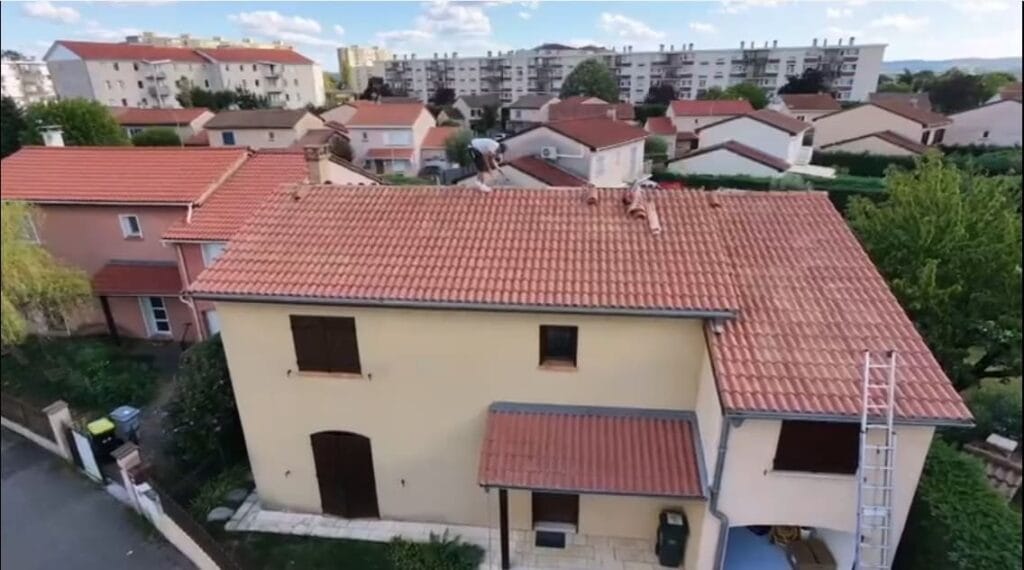 Vue aérienne par drone d'un couvreur remplaçant un closoir de noue après une fuite à Corbas