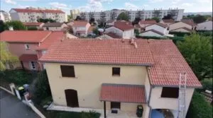 Vue aérienne par drone d'un couvreur remplaçant un closoir de noue après une fuite à Corbas