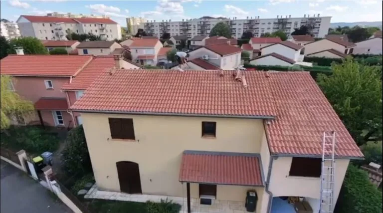 Vue aérienne par drone d'un couvreur remplaçant un closoir de noue après une fuite à Corbas